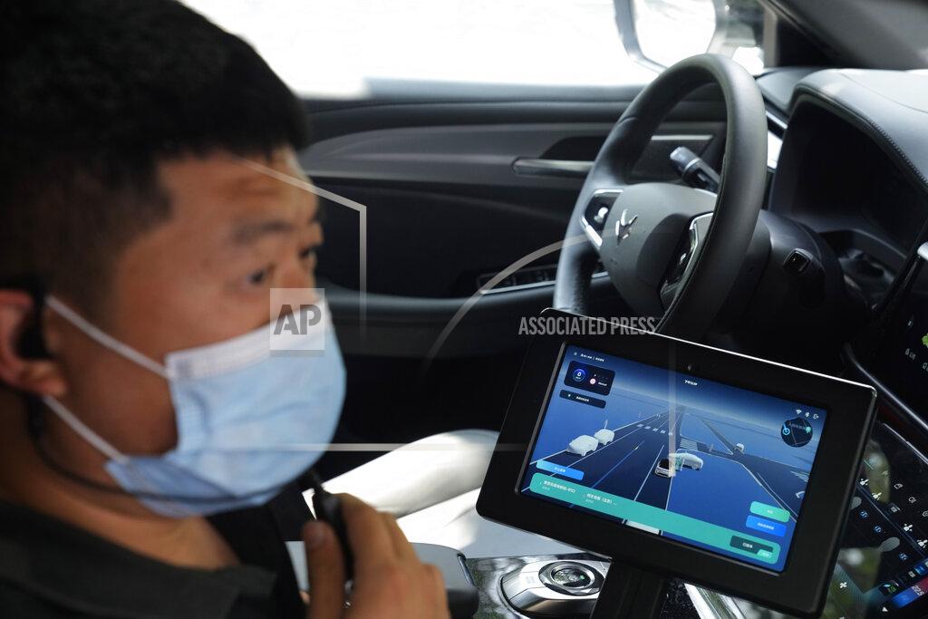 Ng Han Guan A technician sits on the passenger side near a screen that displays the environment seen by a self-driving taxi developed by tech giant Baidu Inc. on June 14, 2022, in Beijing. Baidu Inc. is China's highest-profile competitor in a multibillion-dollar race with Alphabet Inc.'s Waymo and General Motors Co.'s Cruise to create self-driving cars. (AP Photo/Ng Han Guan)