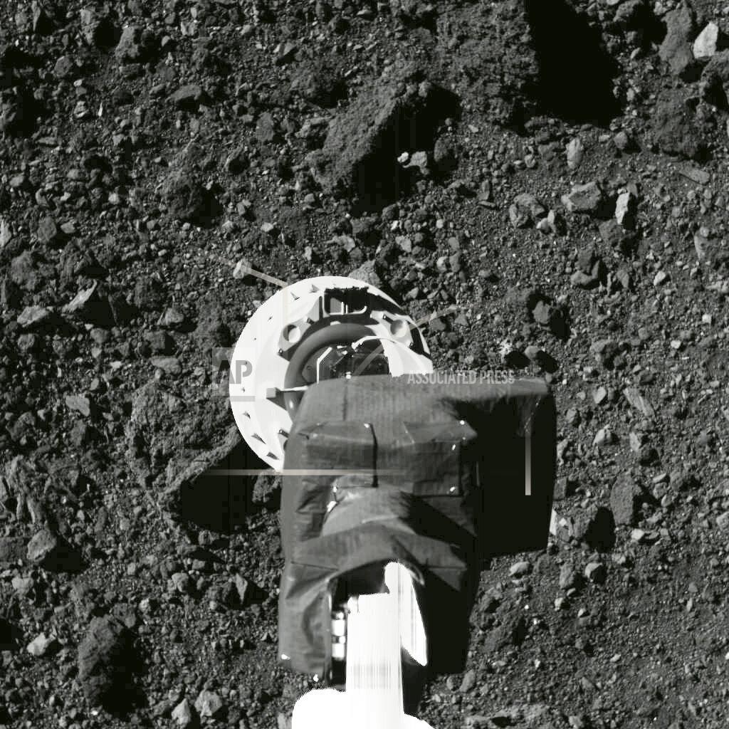 This Aug. 11, 2020 photo shows the sampling arm of the OSIRIS-REx spacecraft during a rehearsal for an approach to the "Nightingale" sample site on the surface of the asteroid Bennu. After almost two years circling the ancient asteroid, OSIRIS-REx will attempt to descend to the treacherous, boulder-packed surface and snatch a handful of rubble on Tuesday, Oct. 20, 2020. (NASA/Goddard/University of Arizona via AP)