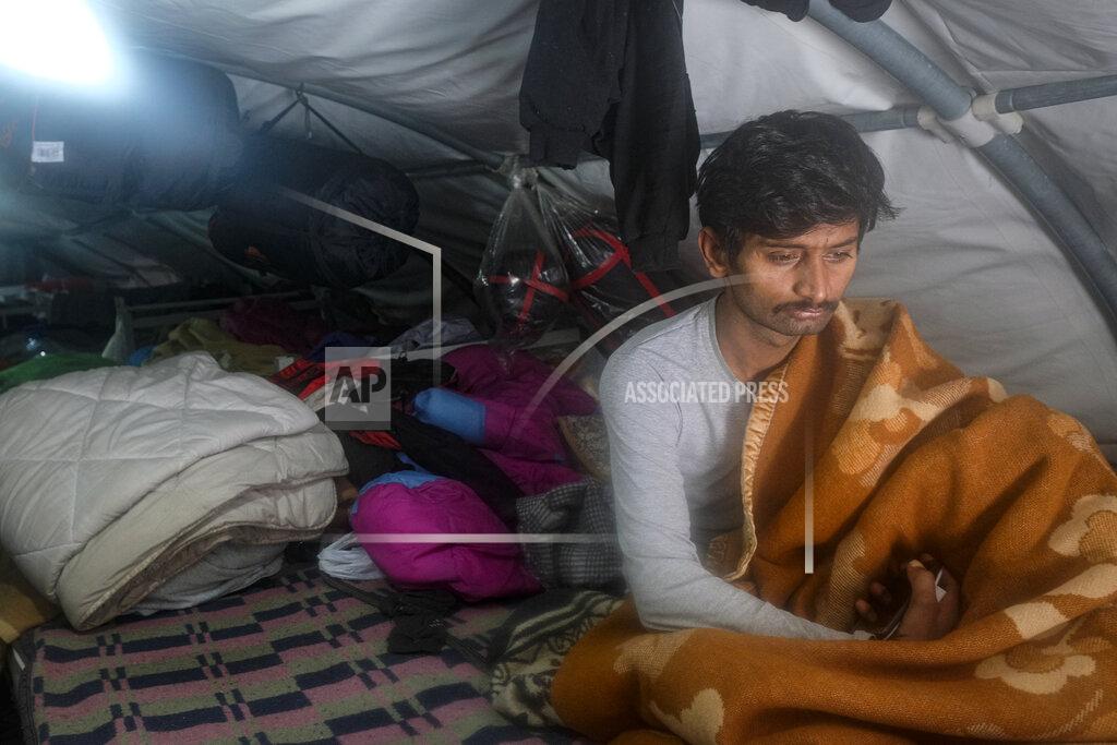 Kemal Softic A migrant sits in a tent at the Lipa camp, outside Bihac, Bosnia, Monday, Jan. 11, 2021. Aid workers say migrants staying at a camp in northwestern Bosnia have complained or respiratory and skin diseases after spending days in make-shift tents and containers amid freezing weather and snow blizzards. Most of the hundreds of migrants at the Lipa facility near Bosnia's border with Croatia on Monday have been accommodated in heated military tents following days of uncertainty after a fire gutted most of the camp on Dec. 23.(AP Photo/Kemal Softic)