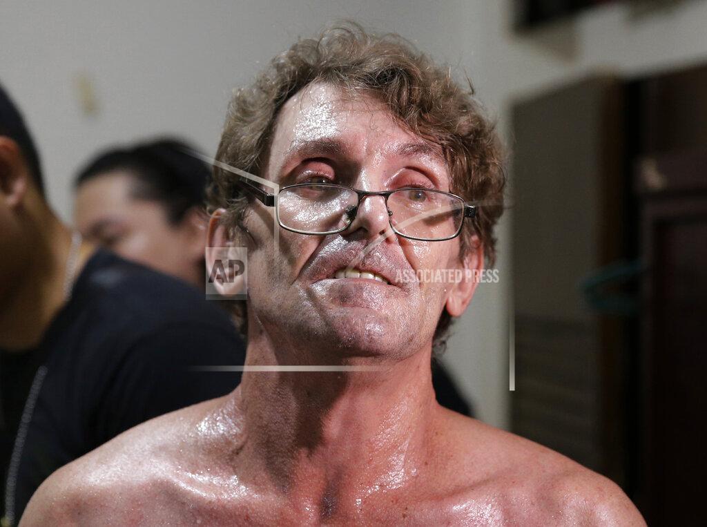 Aaron Favila Suspected child webcam cybersex operator, American David Timothy Deakin, from Peoria, Ill., waits following his arrest as investigators gather evidence during a raid at his home in Mabalacat, northern Philippines, April 20, 2017. A Philippine court has convicted Deakin who exploited Filipino children sexually using webcams to sell videos, images and livestreams to pedophile buyers abroad, an official said Wednesday, May 27, 2020. (AP Photo/Aaron Favila)