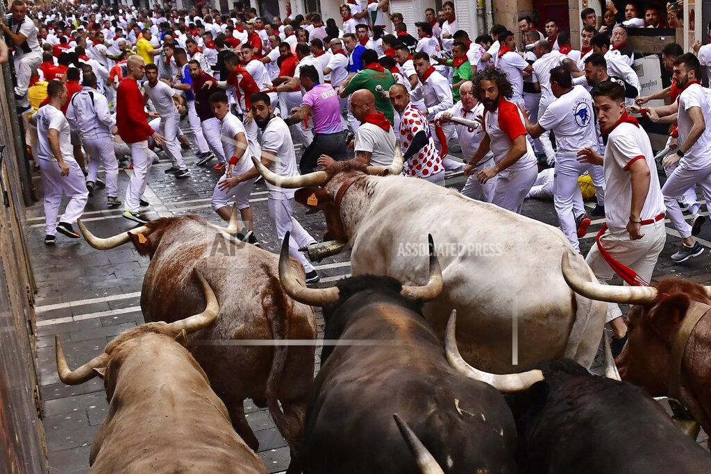 Alvaro Barrientos People run through the streets with fighting bulls and steers during the first day of the running of the bulls at the San Fermin Festival in Pamplona, northern Spain, Thursday, July 7, 2022. Revelers from around the world flock to Pamplona every year for nine days of uninterrupted partying in Pamplona's famed running of the bulls festival which was suspended for the past two years because of the coronavirus pandemic. (AP Photo/Alvaro Barrientos)