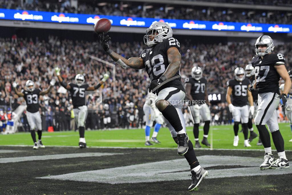 Las Vegas Raiders running back Josh Jacobs (28) celebrates after scoring a touchdown against the Los Angeles Chargers during the first half of an NFL football game, Sunday, Jan. 9, 2022, in Las Vegas. (AP Photo/David Becker)