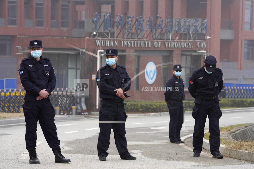 Ng Han Guan Security personnel gather near the entrance of the Wuhan Institute of Virology during a visit by the World Health Organization team in Wuhan in China's Hubei province on Wednesday, Feb. 3, 2021. (AP Photo/Ng Han Guan)