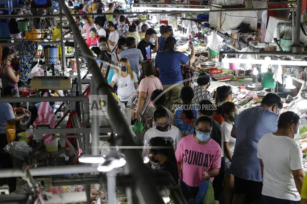 Aaron Favila People wearing face masks and face shields to prevent the spread of the coronavirus buy food at the Munoz market in Quezon city, Philippines as they prepare for a stricter lockdown on Sunday March 28, 2021. The government will start stricter lockdown measures next week as the country struggles to control an alarming surge in COVID-19 cases. (AP Photo/Aaron Favila)