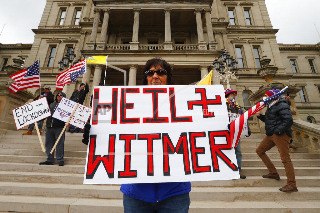 Paul Sancya Dawn Perreca protest in Lansing, Mich., Wednesday, April 15, 2020. Flag-waving, honking protesters drove past the Michigan Capitol on Wednesday to show their displeasure with Gov. Gretchen Whitmer's orders to keep people at home and businesses locked during the new coronavirus COVID-19 outbreak. (AP Photo/Paul Sancya)