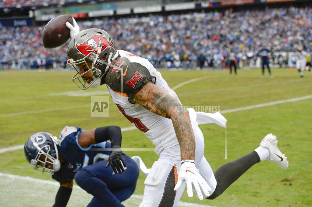 Mark Zaleski Tampa Bay Buccaneers wide receiver Mike Evans (13) scores a touchdown against Tennessee Titans cornerback Logan Ryan, left, on a 2-yard pass play in the second half of an NFL football game Sunday, Oct. 27, 2019, in Nashville, Tenn. (AP Photo/Mark Zaleski)