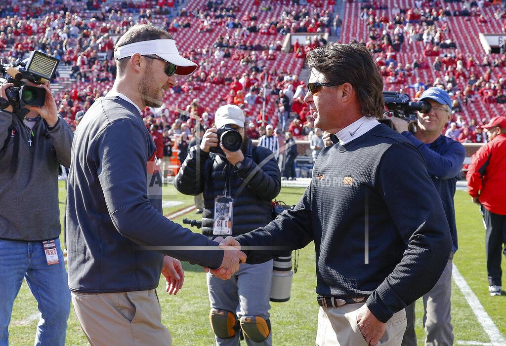 Alonzo Adams FILE - In this Nov. 10, 2018, file photo, Oklahoma head coach Lincoln Riley, left, and Oklahoma State head coach Mike Gundy, right, meet mid field before the start of an NCAA college football game in Norman, Okla. For the four-time defending Big 12 champion Sooners, still trying to get back to the College Football Playoff for the fourth time in five seasons, Bedlam is another long standing rivalry against a Big 12 foe. (AP Photo/Alonzo Adams, File)