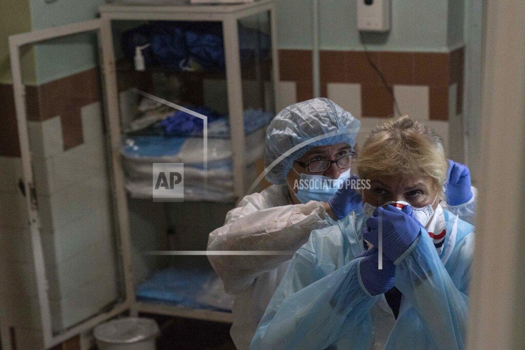 Evgeniy Maloletka Medical workers help each other don protective suits at a hospital in Stebnyk, Ukraine, on Tuesday, Sept. 29, 2020. As coronavirus cases increase, every bed in the hospital in this city in western Ukraine is in use and its chief doctor is watching the surge with alarm and anguish. (AP Photo/Evgeniy Maloletka)