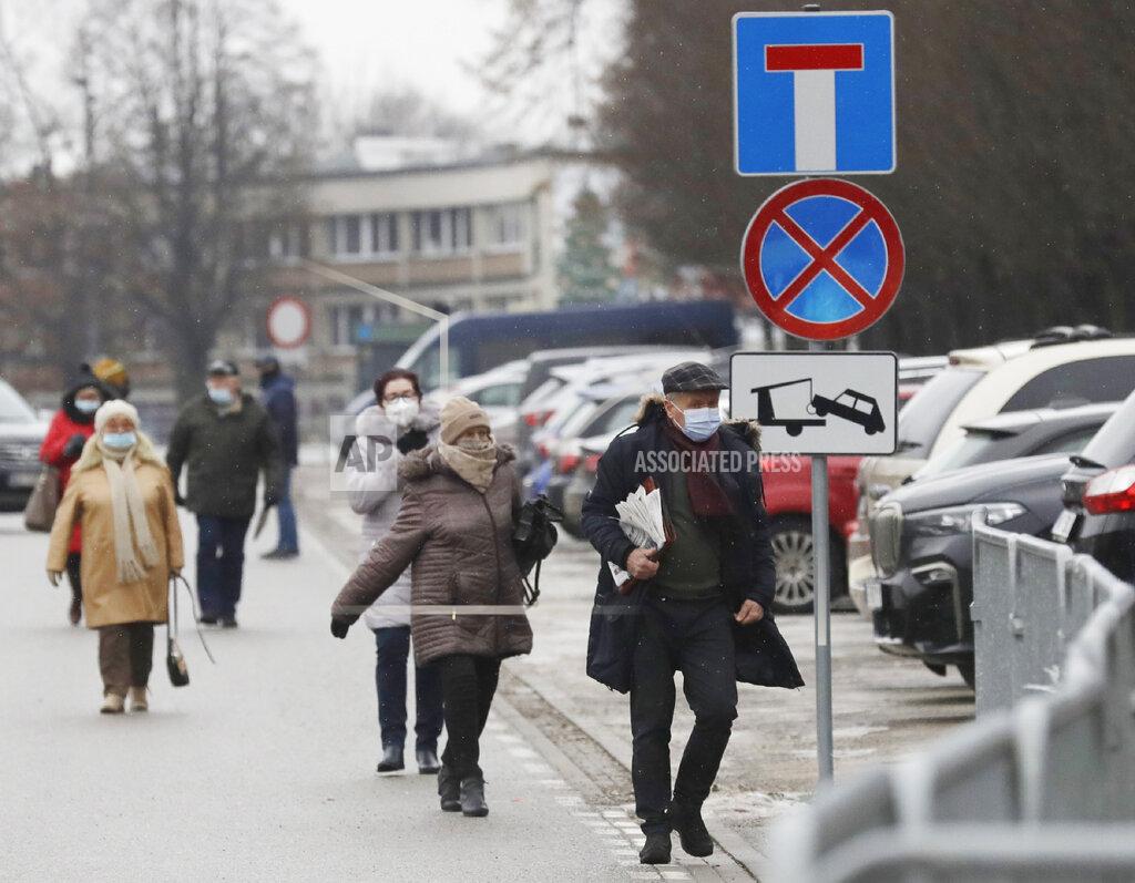 Elderly people arrive to be vaccinated against COVID-19 at the temporary hospital at the National Stadium in Warsaw, Poland, on Monday, Jan. 25, 2021. Overload of online registration system and reduced deliveries of the Pfizer vaccines are causing delays in the national inoculation procedure that currently aims at vaccinating people aged over 70. (AP Photo/Czarek Sokolowski)