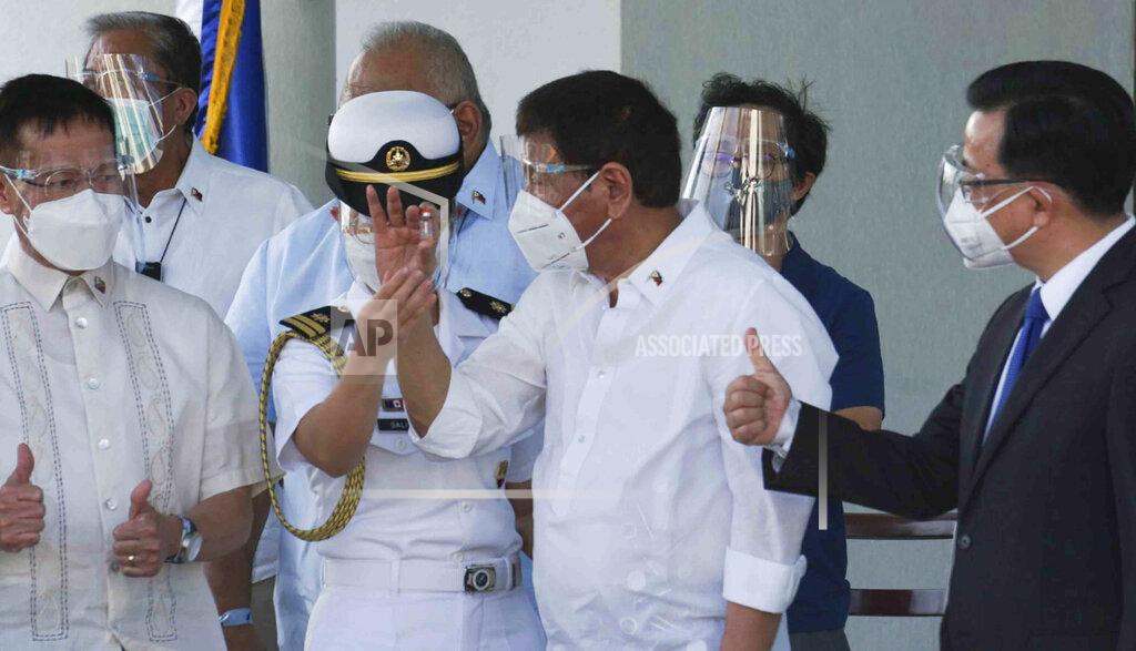 Uncredited In this photo provided by the Presidential Communications Operations Office-Office of the Global Media Public Affairs, Philippine President Rodrigo Duterte, center, holds a vial containing the Sinovac vaccine from China as it arrives at the Villamor Air Base in Manila, Philippines on Sunday Feb. 28, 2021. The Philippines is due to receive its first batch of COVID-19 vaccine Sunday, among the last in Southeast Asia to secure the critical doses despite having the second-highest number of coronavirus infections and deaths in the hard-hit region. (PCOO-OGMPA via AP)