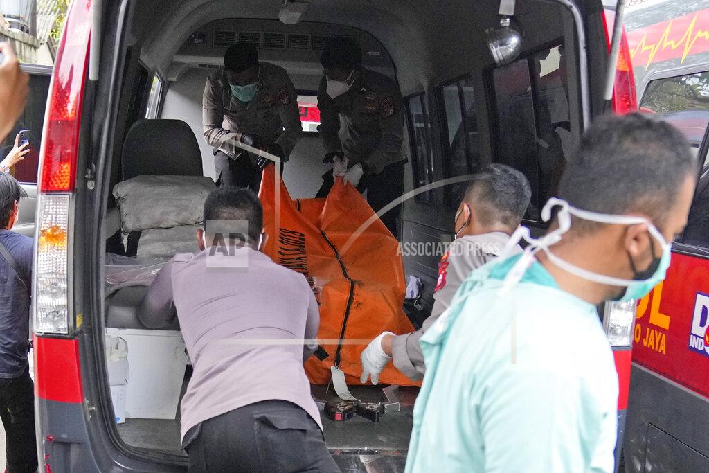Dita Alangkara Officers load a body bag containing the body of a victim of a prison fire to be transferred to the national police hospital for identification from the local hospital's morgue in Tangerang on the outskirts of Jakarta, Indonesia, Wednesday, Sept. 8, 2021. A massive fire raged through an overcrowded prison near Indonesia's capital early Wednesday, killing a number of inmates. (AP Photo/Dita Alangkara)