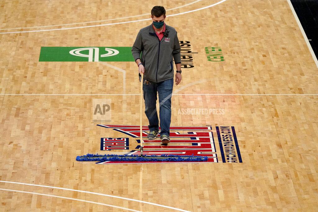 Jeff Roberson A worker cleans the court after it was announced that an NCAA college basketball game in the quarterfinal round of the Missouri Valley Conference men's tournament between Northern Iowa and Drake has been cancelled Friday, March 5, 2021, in St. Louis. (AP Photo/Jeff Roberson)