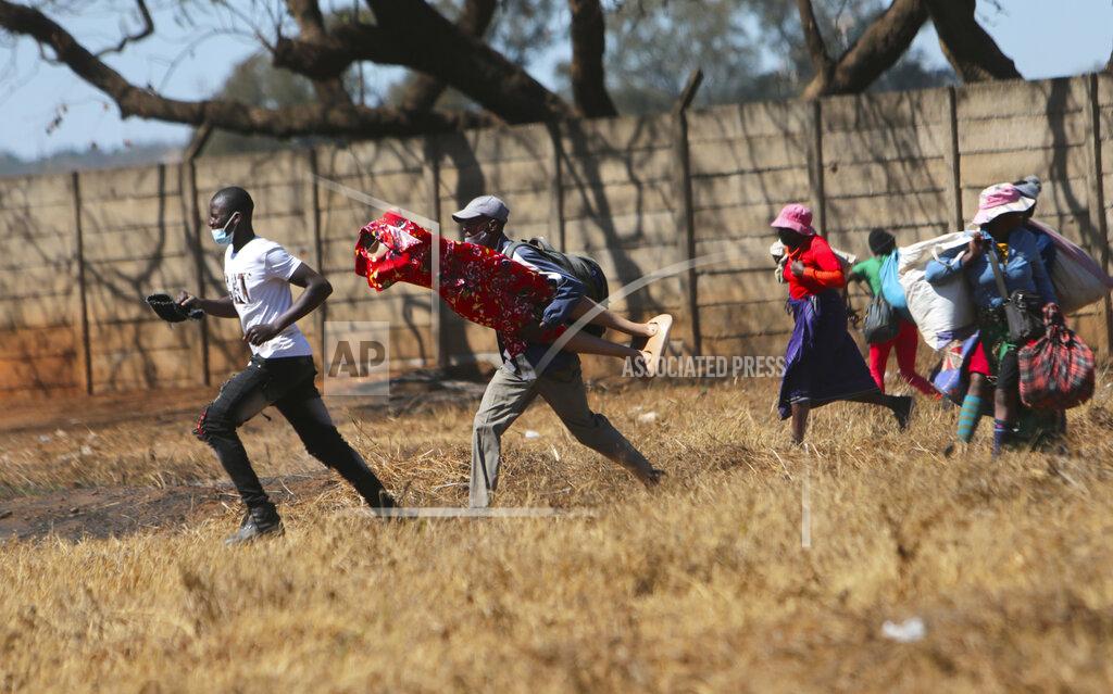 Tsvangirayi Mukwazhi Zimbabwean vendors flee from the police after they were chased away from selling their wares from undesignated areas due to COVID-19 restrictions in Harare, Thursday July 29, 2021.(AP Photo/Tsvangirayi Mukwazhi)