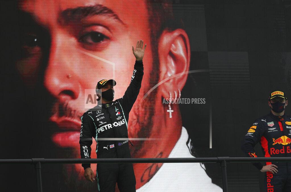 Jose Sena Goulao Mercedes driver Lewis Hamilton of Britain, left, waves from the podium after his record breaking win during the Formula One Portuguese Grand Prix at the Algarve International Circuit in Portimao, Portugal, Sunday, Oct. 25, 2020. (Jose Sena Goulao, Pool via AP)