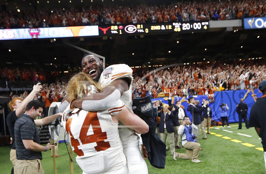 Gerald Herbert Texas defensive back Kris Boyd (2) hugs defensive lineman Breckyn Hager (44) after Texas defeated Georgia 28-21 in the Sugar Bowl NCAA college football game in New Orleans, Tuesday, Jan. 1, 2019. (AP Photo/Gerald Herbert)