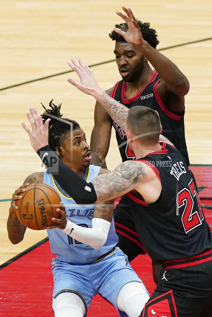 Nam Y. Huh Memphis Grizzlies guard Ja Morant, left, looks to pass the ball as Chicago Bulls center Daniel Theis, right, and forward Patrick Williams defend during the first half of an NBA basketball game in Chicago, Friday, April 16, 2021. (AP Photo/Nam Y. Huh)
