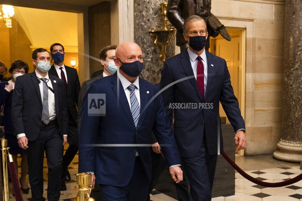 Manuel Balce Ceneta Sen. Mark Kelly, D-Ariz., front left, and and Sen. John Thune, R-S.D. right, walk with fellow senators during a Senate procession carrying boxes holding Electoral College votes through Statuary Hall to the House Chamber for a joint session to confirm the Electoral College votes, Wednesday, Jan. 6, 2021, in Washington. (AP Photo/Manuel Balce Ceneta)