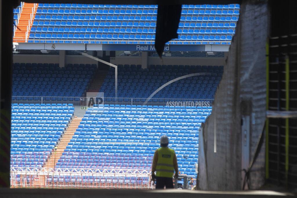 Paul White Workers walk into Real Madrid's Santiago Bernabeu stadium in Madrid, Spain, Monday, May 25, 2020. Spanish league clubs are now allowed to train with groups of up to 14 players as the league stays on track to restart in less than three weeks. (AP Photo/Paul White)