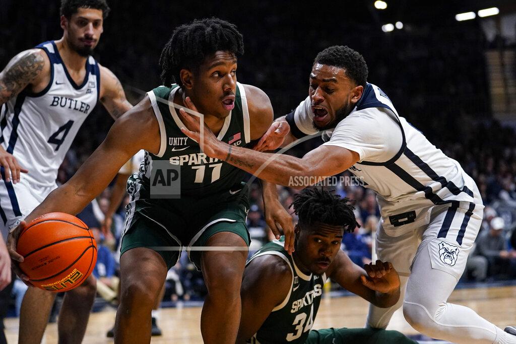 Michael Conroy Michigan State guard A.J. Hoggard (11) picks up a loose ball in front of Butler guard Chuck Harris (3) and Michigan State forward Julius Marble II (34) in the second half of an NCAA college basketball game in Indianapolis, Wednesday, Nov. 17, 2021. Michigan State defeated Butler 73-52. (AP Photo/Michael Conroy)