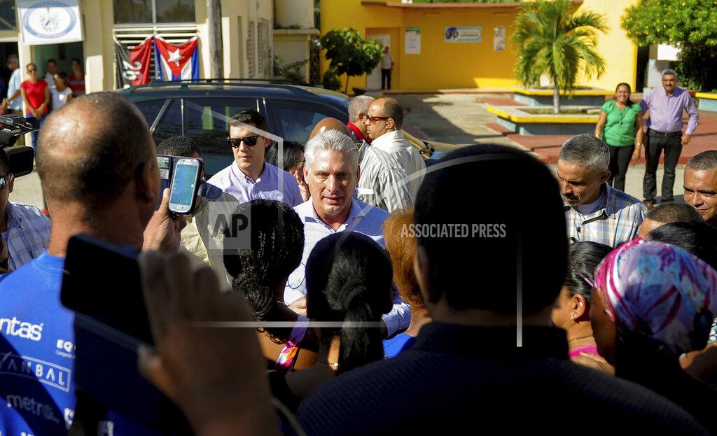 FILE - In this Nov. 14, 2019 file photo, Cuba's President Miguel Diaz-Canel, center, visits with residents after arriving in Caimanera, Cuba. A new decree approved by Diaz-Canel Oct. 8 and made public Monday, Nov. 18, 2019, says prosecutors can approve eavesdropping and surveillance of any form of communication, without consulting a judge as required in many other Latin American countries. (AP Photo/Ismael Francisco, File)