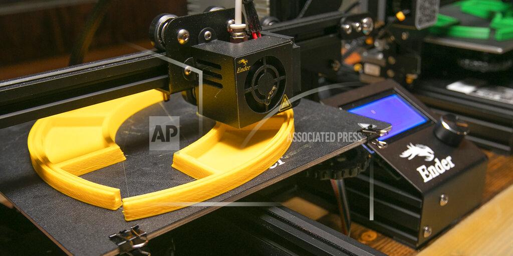 Dave Zajac A protective face shield frame is created on a 3-D printer set up in the building previously occupied by Hop Knot craft beer and pretzel bar in Southington, Conn. Friday, April 17, 2020. (Dave Zajac/Record-Journal via AP)