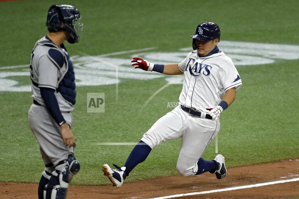 Chris O'meara Tampa Bay Rays' Yoshi Tsutsugo, of Japan, right, scores in front of New York Yankees catcher Gary Sanchez on a sacrifice fly by Michael Perez off Yankees pitcher Adam Ottavino during the eighth inning of a baseball game Friday, Aug. 7, 2020, in St. Petersburg, Fla. (AP Photo/Chris O'Meara)