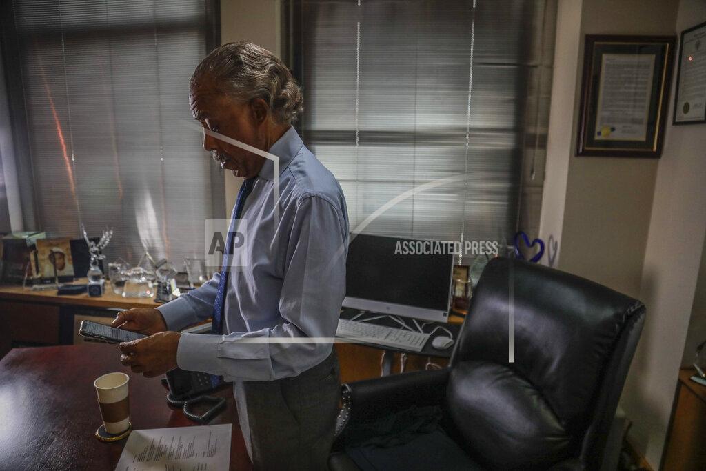 Bebeto Matthews The Rev. Al Sharpton checks phone messages as he finish an interview at his office, Thursday July 30, 2020, in New York. For more than three decades, Sharpton, 65, has been an advocate for Black American families seeking justice in the wake of violence that highlight systemic racism.(AP Photo/Bebeto Matthews)