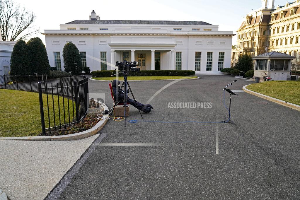 Gerald Herbert A cameraman waits by an unused microphone stand outside the West Wing at the White House, Tuesday, Jan. 19, 2021, in Washington. On President Donald Trump's last full day in office, there was an eerie quiet, with no public events scheduled, his last event being Jan. 12, seven days earlier. (AP Photo/Gerald Herbert)