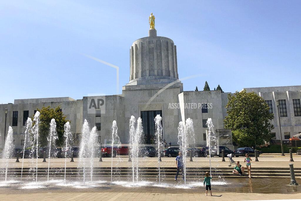 FILE - In this June 29, 2019, file photo, children play in fountains at the Oregon State Capitol in Salem, Ore. Republicans in the Oregon Senate boycotted the Thursday Feb. 25, 2021, session, using a tactic they had employed in the past two years to stop work in the chamber — this time over the state's handling of the coronavirus pandemic. (AP Photo/Andrew Selsky, File)