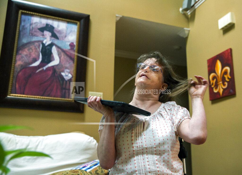 Sophia Germer Jen, a 44-year-old woman with intellectual and developmental disabilities, sings and dances along with Mariah Carey Christmas carols at her home in Metairie, La., Friday, Sept. 17, 2021. (Sophia Germer/The Times-Picayune/The New Orleans Advocate via AP)