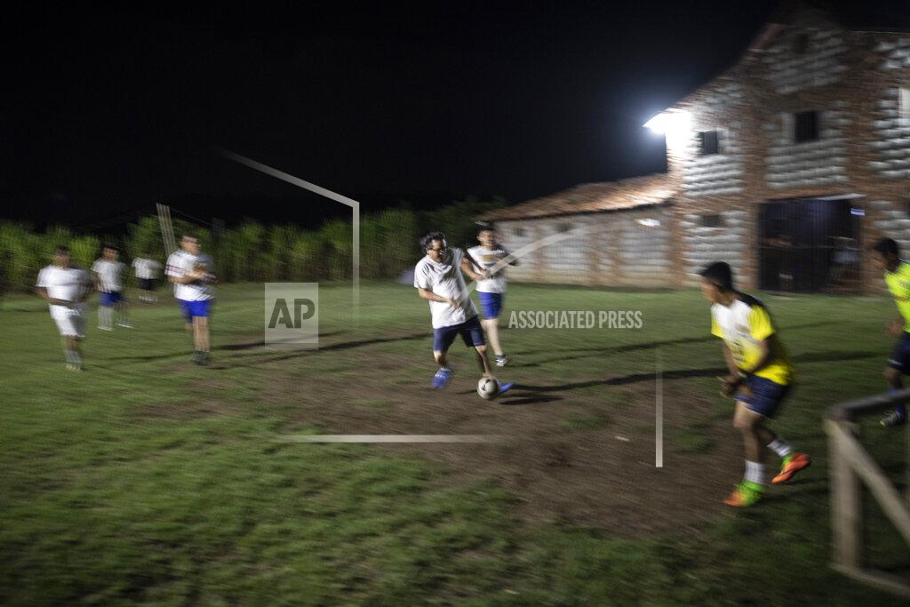 Rodrigo Abd Friar Leopoldo Serrano shoots for a goal while playing soccer with seminarians and residents at his drug rehab center in Mission San Francisco de Asis, Honduras, Monday, June 21, 2021. Since moving to the mission in 2009, Serrano has preached the Bible, organized protest marches against violence, negotiated drug-free events such as soccer matches, and promoted religious celebrations and social work. (AP Photo/Rodrigo Abd)