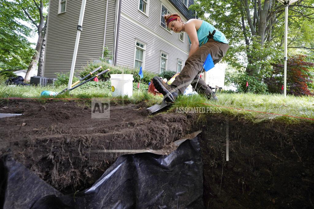 Steven Senne University of Massachusetts Boston graduate student Claire Norton, of Boston, uses a shovel to remove layers of soil while working to uncover artifacts at an excavation site, Wednesday, June 9, 2021, on Cole's Hill, in Plymouth, Mass. Norton is part of a team of archaeologists excavating the grassy hilltop that overlooks iconic Plymouth Rock one last time before a historical park is built on the site. (AP Photo/Steven Senne)