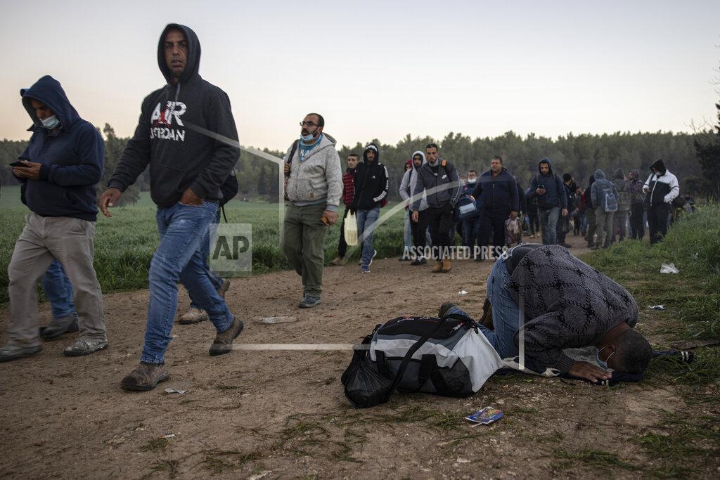 Tsafrir Abayov A Palestinian man prays as laborers cross illegally into Israel from the West Bank through an opening in a fence, south of the West Bank town of Hebron near the Israeli city of Kiryat Gat, Israel, Sunday, Feb. 14, 2021. (AP Photo/Tsafrir Abayov)