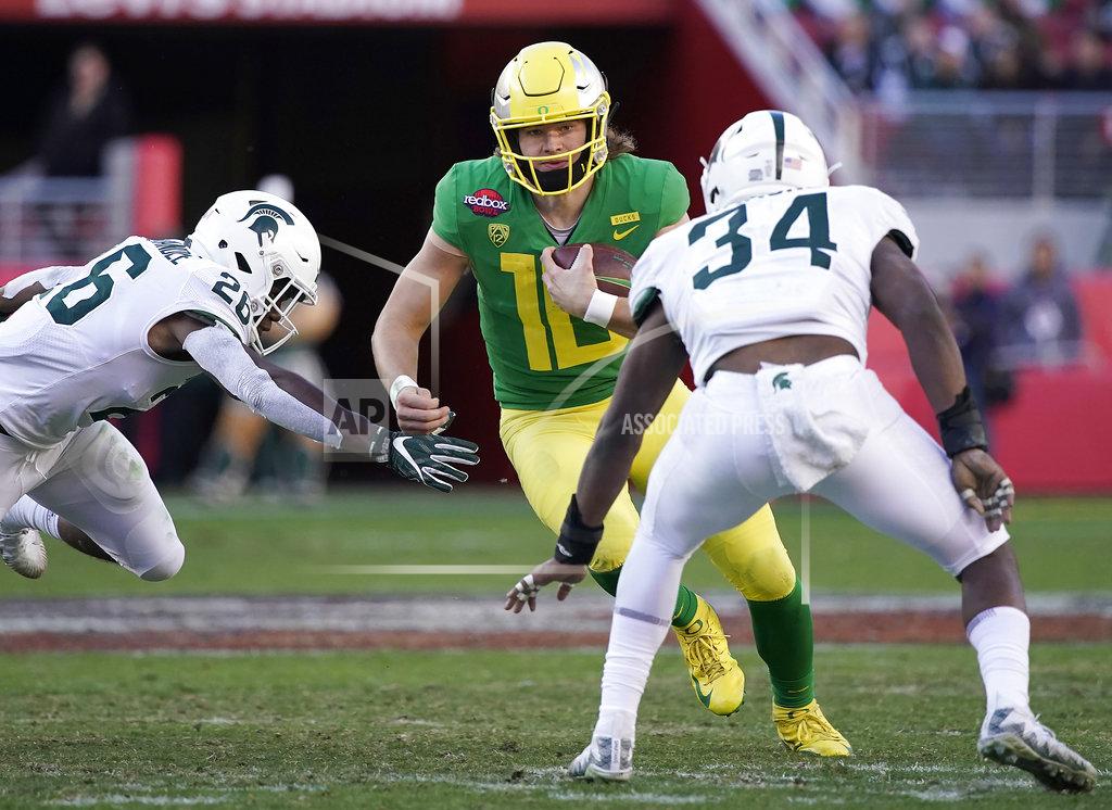Tony Avelar Oregon quarterback Justin Herbert (10) scrabbles out of the pocket between Michigan State linebackers Brandon Bouyer-Randle (26) and Antjuan Simmons (34) during the second half of the Redbox Bowl NCAA college football game Monday, Dec. 31, 2018, in Santa Clara, Calif. Oregon won 7-6. (AP Photo/Tony Avelar)