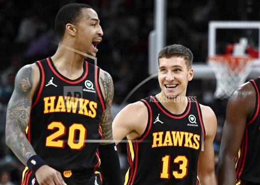 Atlanta Hawks' Bogdan Bogdanovic (13) and John Collins celebrate a basket late in the second half of an NBA basketball game against the San Antonio Spurs, Wednesday, Nov. 24, 2021, in San Antonio. Atlanta won 124-106. (AP Photo/Darren Abate)