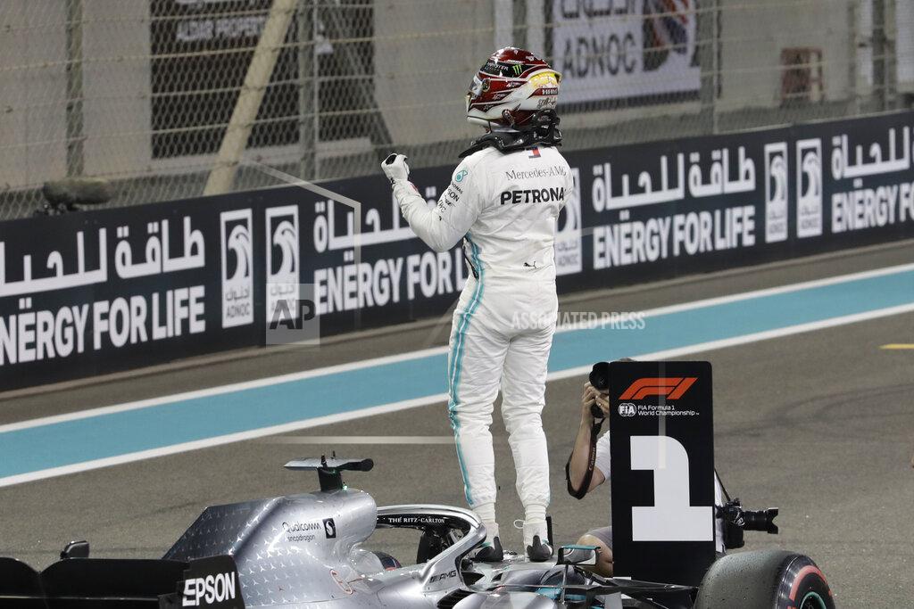 Luca Bruno Mercedes driver Lewis Hamilton of Britain celebrates pole position during the qualifying session at the Yas Marina racetrack in Abu Dhabi, United Arab Emirates, Saturday, Nov. 30, 2019. The Emirates Formula One Grand Prix will take place on Sunday. (AP Photo/Luca Bruno)