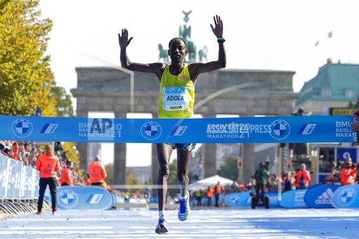 Ethiopia's Guye Adola celebrates as he crosses the finish line to win the Berlin Marathon in Berlin, Germany, Sunday, Sept. 26, 2021. (AP Photo/Lisa Leutner)