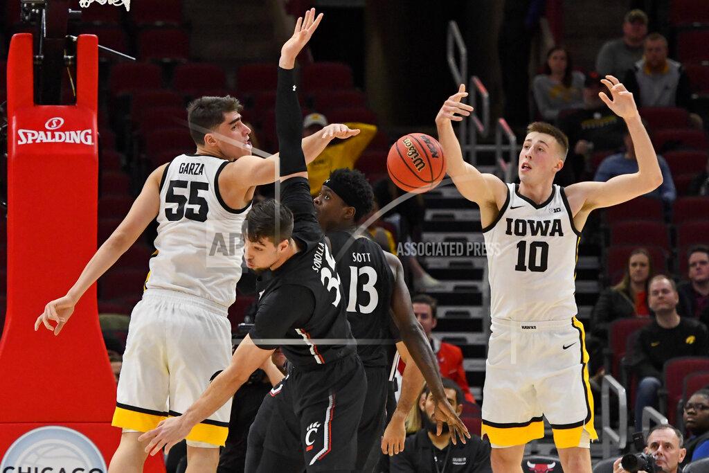 Matt Marton Cincinnati center Jaume Sorolla, front, and forward Tre Scott (13) chase the ball as do Iowa center Luka Garza (55) and guard Joe Wieskamp (10) during the first half of an NCAA college basketball game Saturday, Dec. 21, 2019, in Chicago. (AP Photo/Matt Marton)