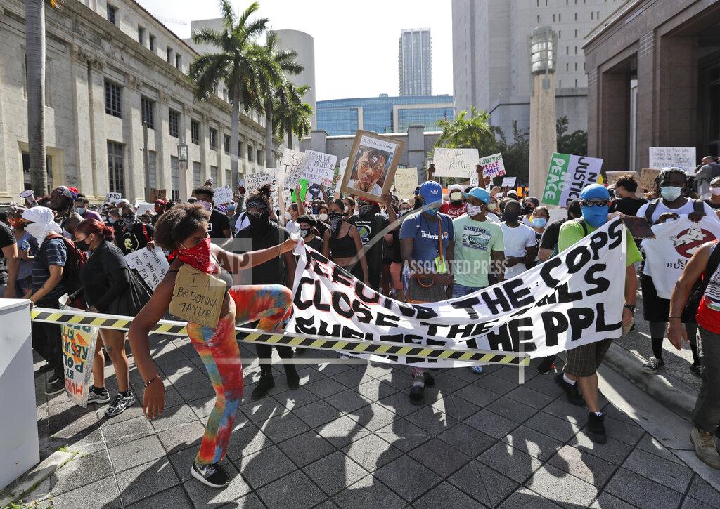 Wilfredo Lee Protesters cross over a barricade as they march in front of the Federal Detention Center, in the death of George Lloyd, Sunday, May 31, 2020, in Miami. (AP Photo/Wilfredo Lee)