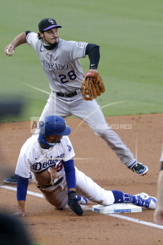 Alex Gallardo Colorado Rockies third baseman Nolan Arenado, above, throws to first, as Los Angeles Dodgers' Mookie Betts, below, slides into third safely, to get Corey Seager in a rundown between first and second base during the first inning of a baseball game in Los Angeles, Saturday, Aug. 22, 2020. (AP Photo/Alex Gallardo)