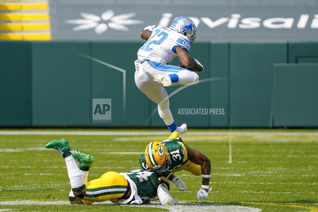 Morry Gash Detroit Lions' D'Andre Swift leaps over Green Bay Packers' Adrian Amos and Raven Greene during the second half of an NFL football game Sunday, Sept. 20, 2020, in Green Bay, Wis. (AP Photo/Morry Gash)