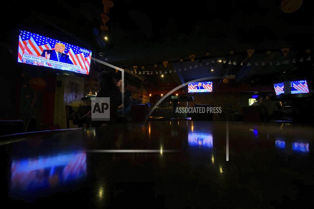 Andy Wong Customers watch TVs showing a live telecast of President Donald Trump speak in the East Room of the White House during the U.S. election, at a quiet pub in Beijing, Wednesday, Nov. 4, 2020. (AP Photo/Andy Wong)