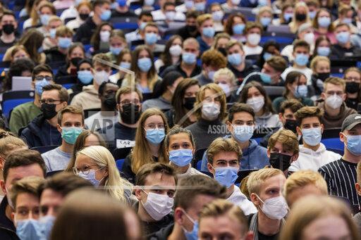 FILE - In this Monday, Oct. 11, 2021 file photo, students wear mouth-to-nose coverings while sitting close to each other during the lecture 'BWL 1' in lecture hall H1 of the Westfaelische Wilhelms-Universitaet in Muenster, Germany. The German parliament will not extend the 'epidemic situation of national scope' when it expires next month, but keep in place certain measures to prevent the spread of the coronavirus. (Rolf Vennenbernd/dpa via AP)