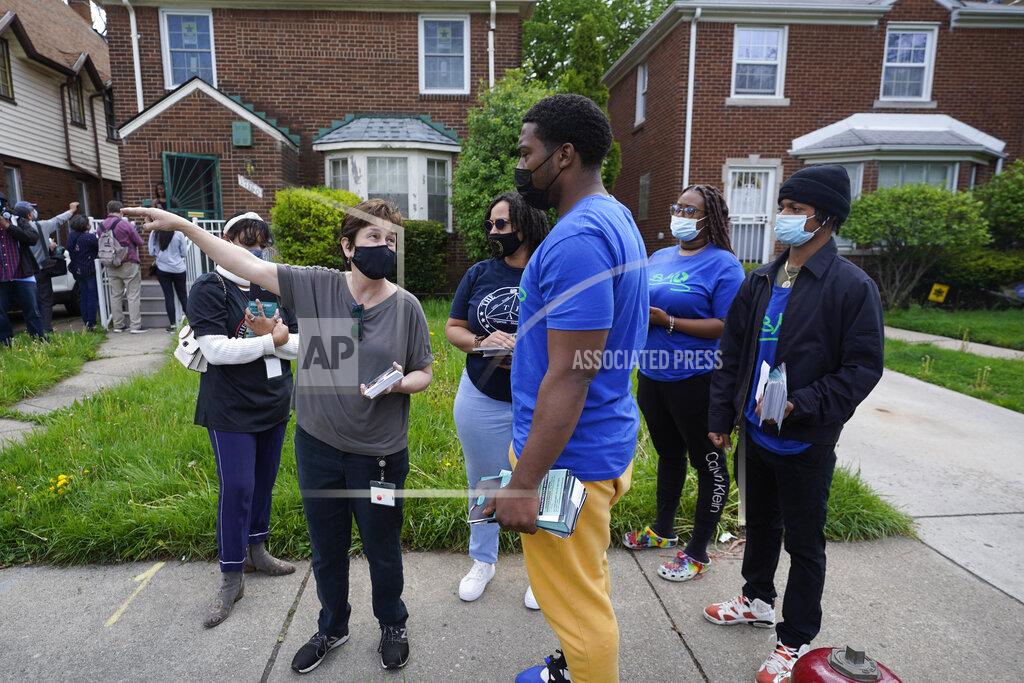 Paul Sancya Volunteers meet before fanning out to place flyers on homes in Detroit, Tuesday, May 4, 2021. Officials are walking door-to-door to encourage residents of the majority Black city to get vaccinated against COVID-19 as the city's immunization rate lags well behind the rest of Michigan and the United States. (AP Photo/Paul Sancya)