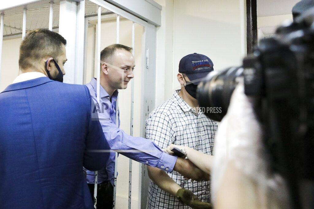 Sofia Sandurskaya Ivan Safronov, an adviser to the director of Russia's state space corporation, second left, shakes hands with his supporters standing behind bars in a courtroom in Moscow, Russia, Tuesday, July 7, 2020. Safronov, a former journalist who worked as an adviser to the director of the Russian state space corporation, pleaded innocent to the treason charges against him. Ivan Safronov, a former journalist who served as an adviser to Roscosmos head Dmitry Rogozin, was detained in Moscow by agents of the Federal Security Service (FSB), the main KGB successor agency. (Sofia Sandurskaya, Moscow News Agency photo via AP)