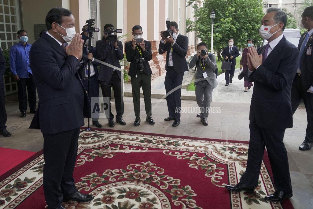 Kith Serey Chinese Foreign Minister Wang Yi, foreground right, greets with his Cambodian counterpart Prak Sokhonn, foreground left, in Phnom Penh, Cambodia, Sunday, Sept. 12, 2021. Wang is visiting Cambodia, where's he expected to meet with Prime Minister Hun Sen and other officials to discuss COVID-19 and other regional issues. (Kith Serey/Photo Photo via AP)