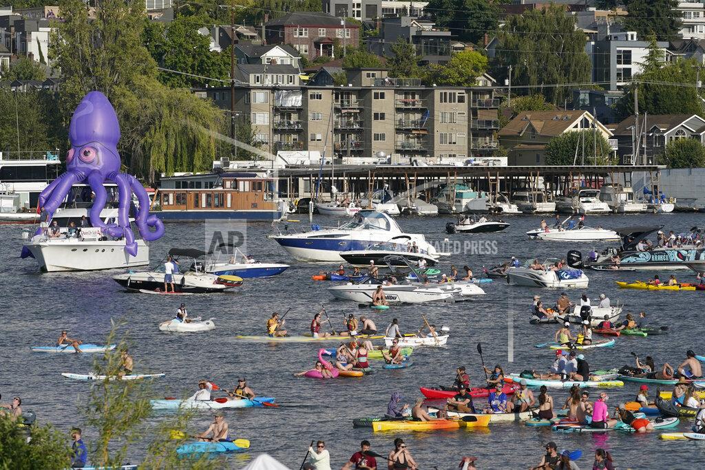 Ted S. Warren Fans on kayaks and boats, including one sporting a giant inflatable octopus, float on Lake Union, Wednesday, July 21, 2021, during the Seattle Kraken's NHL hockey expansion draft event in Seattle. (AP Photo/Ted S. Warren)