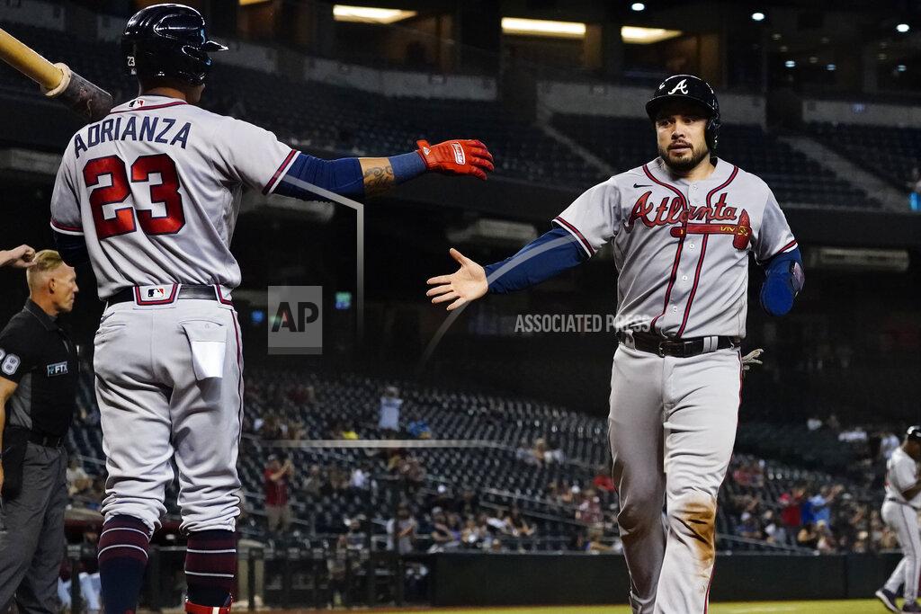 Matt York Atlanta Braves' Travis d'Arnaud greets Ehire Adrianza (23) as he scores on a base hit by Dansby Swanson during the ninth inning of a baseball game against the Arizona Diamondbacks, Tuesday, Sept. 21, 2021, in Phoenix. (AP Photo/Matt York)