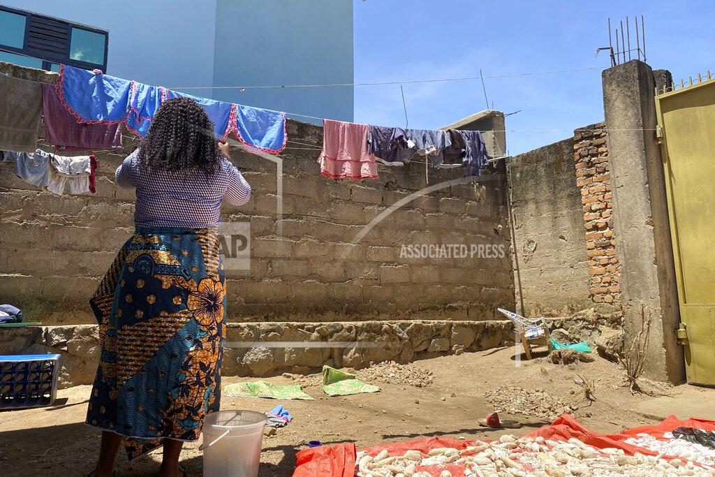 Kudra Maliro Reby hangs laundry outside her home in Beni, eastern Congo, on Saturday, May 1, 2021. In 2019, she met World Health Organization Dr. Boubacar Diallo, of Canada, when he came into a mobile phone shop where she was working. He asked her to talk about “important things” with him in a hotel and gave her $100 for “transport costs,” she told the AP. “My God, a beautiful girl like you who gets $60 a month is not enough,” he said, according to Reby. “You are a big girl and if you sleep with me, you are going to be a high-ranking member of the Ebola response in Beni and you are going to receive around $800 a month.” She said she refused Diallo’s offer, but continued to see him when he came into her shop. “From that day on, he always called me the difficult girl,” she said. (AP Photo/Kudra Maliro)