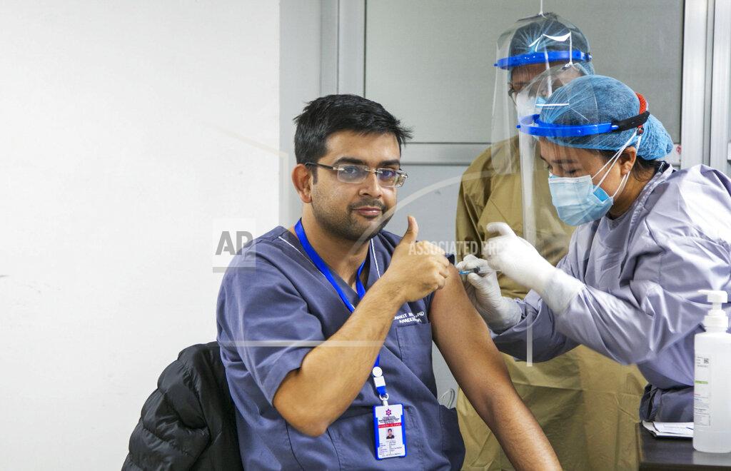 Niranjan Shrestha A Nepalese doctor shows thumbs up as he receives AstraZeneca/Oxford University vaccine, at Teaching Hospital in Kathmandu, Nepal, Wednesday, Jan. 27, 2021. Thousands of health workers lined up across Nepal to get the coronavirus vaccine Wednesday as the Himalayan nation began its campaign to get the population vaccinated within three months. Neighboring India gifted Nepal 1 million doses of the vaccine manufactured under license by the Serum Institute of India. (AP Photo/Niranjan Shrestha)